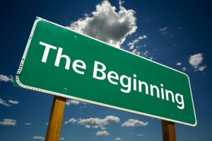 "The Beginning" Road Sign with dramatic blue sky and clouds.